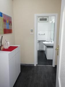 ein weißes Badezimmer mit einem Waschbecken und einem Spiegel in der Unterkunft APT. Re Nasone in Caserta