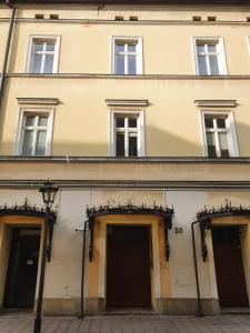 a large building with three doors and windows at Exclusive Loft in the Main Square A/C p4you pl in Krakow