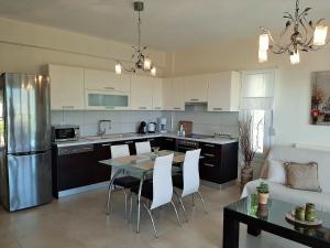 a kitchen and living room with a table and chairs at Bel Air in Skala Potamias