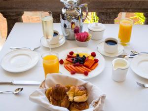 a white table with a plate of food and orange juice at Casa Kimberly Boutique Hotel in Puerto Vallarta