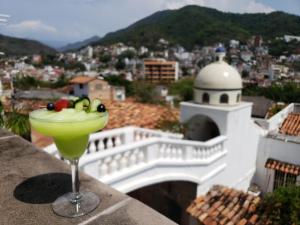 uma bebida numa saliência com vista para uma cidade em Casa Kimberly Boutique Hotel em Puerto Vallarta