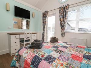 een slaapkamer met een bed met een quilt bij Chalet 279 in Bridlington