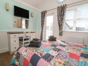 a bedroom with a bed with a quilt on it at Shore Thing 279 in Bridlington