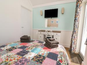een slaapkamer met een bed en een tv aan de muur bij Chalet 279 in Bridlington