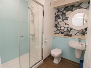 a bathroom with a shower and a toilet and a sink at Shore Thing 279 in Bridlington +5 photos