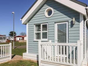 une petite maison bleue avec une clôture blanche dans l'établissement Chalet 279, à Bridlington