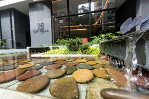 
a stone wall with a bunch of plants in front of it at Lettera Hotel in Medellín
