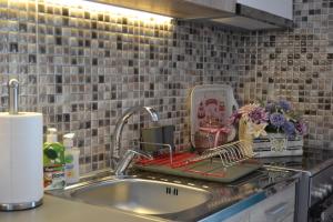 a kitchen counter with a sink and a tiled wall at Michalis Captain Home in Agia Galini