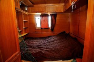a small room with a bed in the middle of it at HOUSEBOAT Mazury Frajda in Giżycko