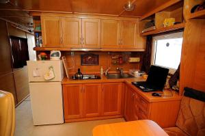 a kitchen with a refrigerator and a laptop on the counter at HOUSEBOAT Mazury Frajda in Giżycko