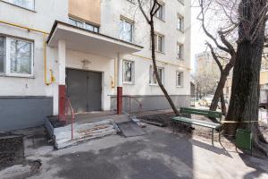 un edificio con una puerta y un árbol delante de él en Economy Brusnika Apartment Kuzminki, en Moscú