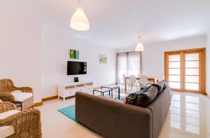 a living room with a couch and a table at AL- Apartamentos Novos Vista Mar in Quarteira