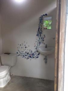 a bathroom with a toilet and a sink at La Aldea Hostel, Camping y Hamacas in Palomino