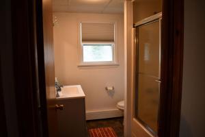 uma casa de banho com um lavatório, um WC e uma janela. em Brook Road Condo em Goshen