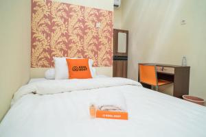 Cette chambre comprend un lit avec une boîte orange. dans l'établissement KoolKost Syariah at Ir Soekarno Solo Baru, à Solo