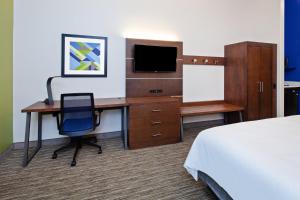 a hotel room with a desk with a bed and a television at Holiday Inn Express & Suites Rancho Mirage - Palm Spgs Area, an IHG Hotel in Rancho Mirage
