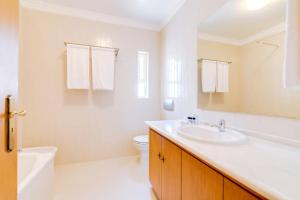 a white bathroom with a sink and a toilet at AL- Apartamentos Novos Vista Mar in Quarteira +30 photos