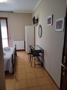 Habitación pequeña con mesa y nevera. en Villa Eleila Affittacamere, en Terracina