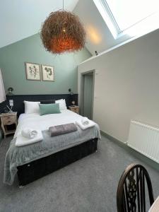 um quarto com uma cama grande e um lustre em The Windmill Inn em Horsham