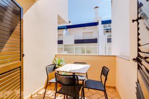 a balcony with a table and chairs on a building at AL- Apartamentos Novos Vista Mar in Quarteira