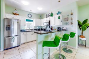 a kitchen with white cabinets and green walls at Las Joyas 104 in Port Isabel