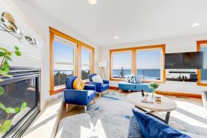 a living room with blue chairs and a fireplace at Blue Wave Heights in Lincoln City