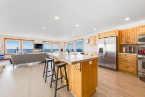 a kitchen with wooden cabinets and stainless steel appliances at Blue Wave Heights in Lincoln City +31 photos