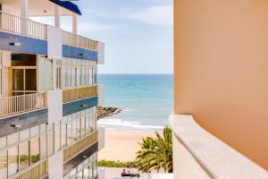 a view of the beach from the balcony of a building at AL- Apartamentos Novos Vista Mar in Quarteira