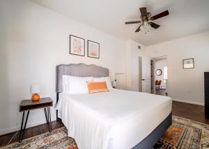 a bedroom with a white bed and a ceiling fan at Unit 1 - Spacious & Renovated Apt Home in the City's Action in Houston