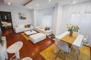 a living room with a white table and chairs at Harmony Apartmani Arandjelovac in Arandjelovac