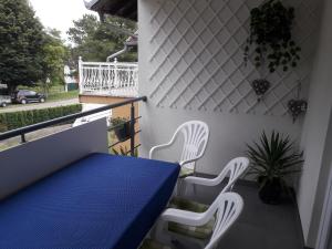 a balcony with a blue table and two white chairs at Apartman Šarm Srebrno jezero in Veliko Gradište