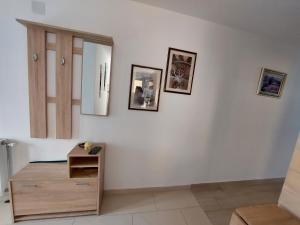 a room with a wooden dresser and pictures on the wall at Apartman Šarm Srebrno jezero in Veliko Gradište