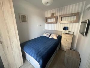 a small bedroom with a bed and a dresser at Apartament W Baltic Cliff in Niechorze