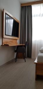 a room with a desk with a television and a chair at HB 32 Metzingen in Metzingen