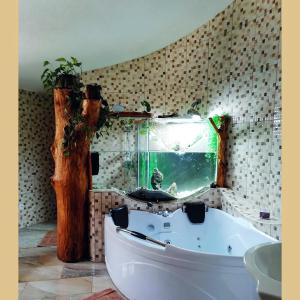 baño con bañera y ventana con pecera en Dovolenkový dom Dubak, en Lopej