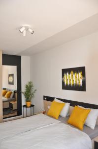 sypialnia z dużym łóżkiem z żółtymi poduszkami w obiekcie MAXIM Apartments w mieście Harkány