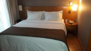 duże łóżko w pokoju hotelowym z telefonem w obiekcie Apartamento no condomínio do Brasil 21 Suites w mieście Brasília