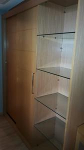 szafa ze szklanymi półkami i drewnianymi drzwiami w obiekcie Apartamento no condomínio do Brasil 21 Suites w mieście Brasília