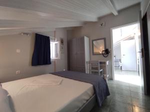 a bedroom with a large bed with a blue blanket at Venus Rooms in Katelios