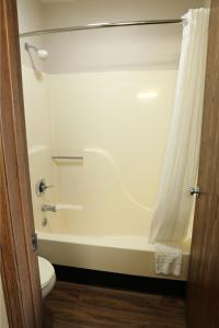 a bathroom with a white tub and a toilet at Econo Inn in Columbus