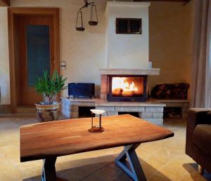 een woonkamer met een open haard en een houten tafel bij Ein Bett im Kornfeld - Haus Fernweh - Innenpool in Schönfeld