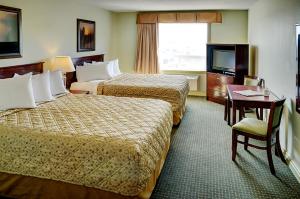 una camera d'albergo con due letti e una televisione di Nova Inn Acheson a Spruce Grove