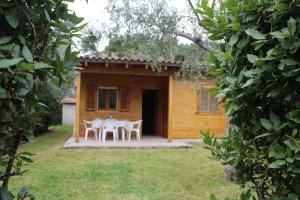 une table et des chaises devant une maison dans l'établissement Agriturismo Lu Podere, à Alimini