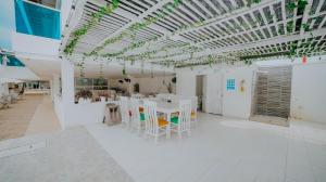 a room with white tables and chairs and a ceiling at Hotel Palma Linda in Coveñas