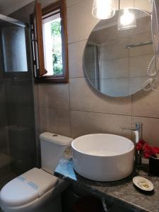 a bathroom with a sink and a toilet and a mirror at Castro Rooms Chios in Chios