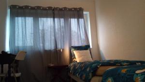 a bedroom with a bed and a window with curtains at chambre lits jumeaux in Chevilly-Larue