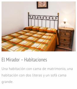 een slaapkamer met een bed, een houten dressoir en een nachtkastje bij El mirador 1 in Alcalá del Júcar