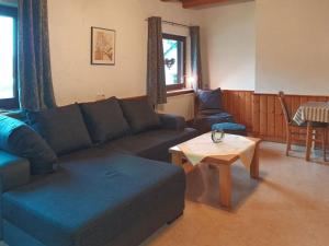 a living room with a blue couch and a table at Ferienwohnung Oberschledorner Wald in Medebach