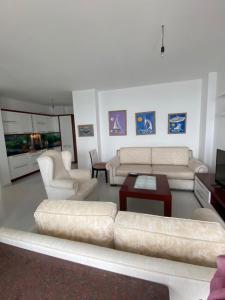 a living room with couches and a table and a couch at Beach Luxury Apartment Shëngjin in Lezhë