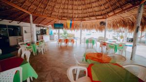 a restaurant with tables and chairs and a view of the ocean at Hotel Kevins in Tolú